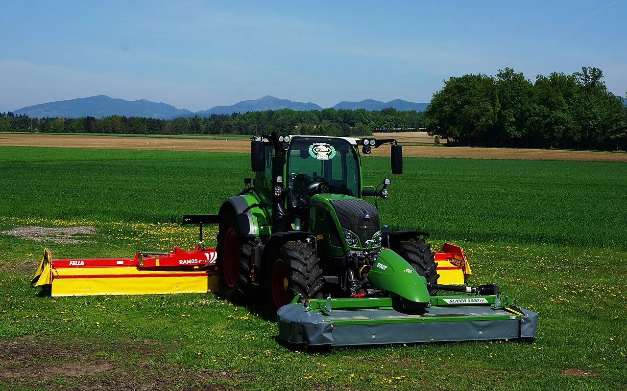 Traktor mit Mähwerk auf Grünland